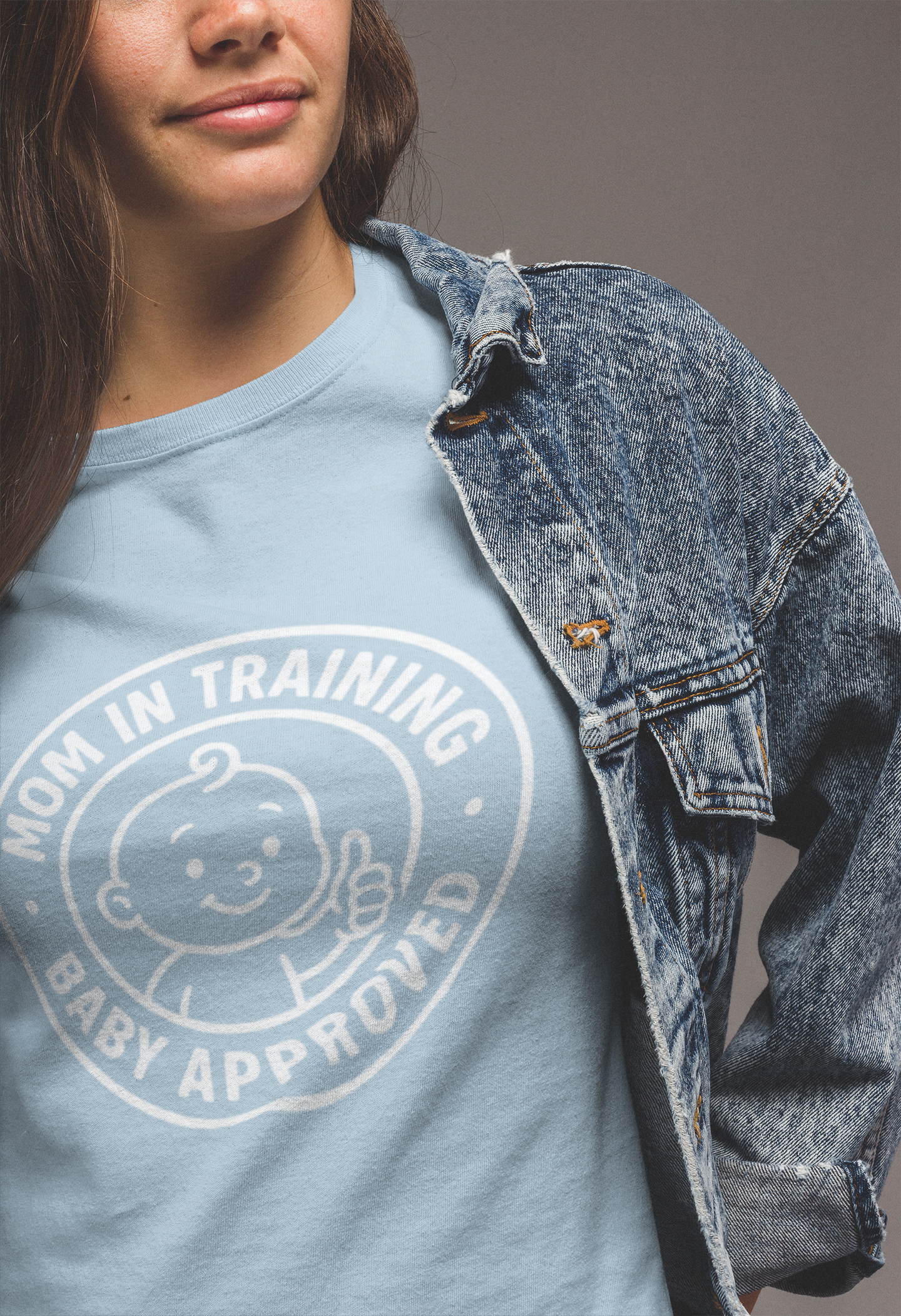 Light‑blue mom shirts design “Mom in Training • Baby Approved” styled under a denim jacket for casual everyday wear.