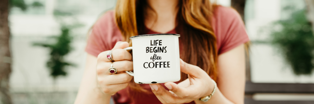 Woman holding a white enamel mug that reads “Life Begins After Coffee,” a charming idea for unique gifts.