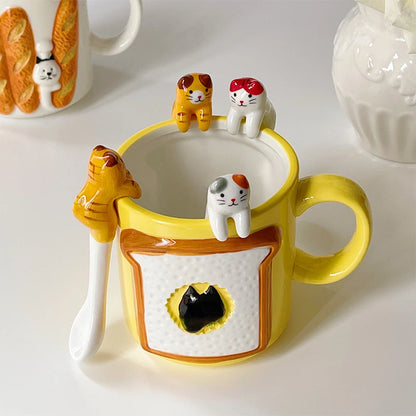 Yellow mug scene featuring three rim‑sitting cat coffee spoons and a matching hanging coffee spoon—playful tabletop funny gifts idea.


